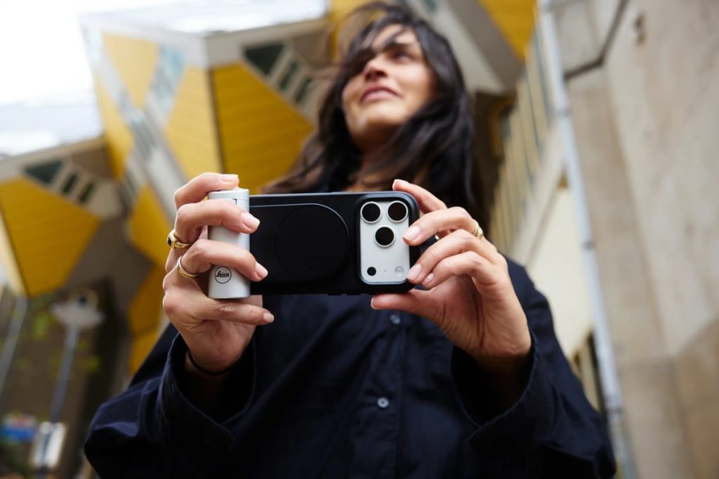 Srebrny uchwyt Leica LUX Grip na iPhonie trzymanym poziomo