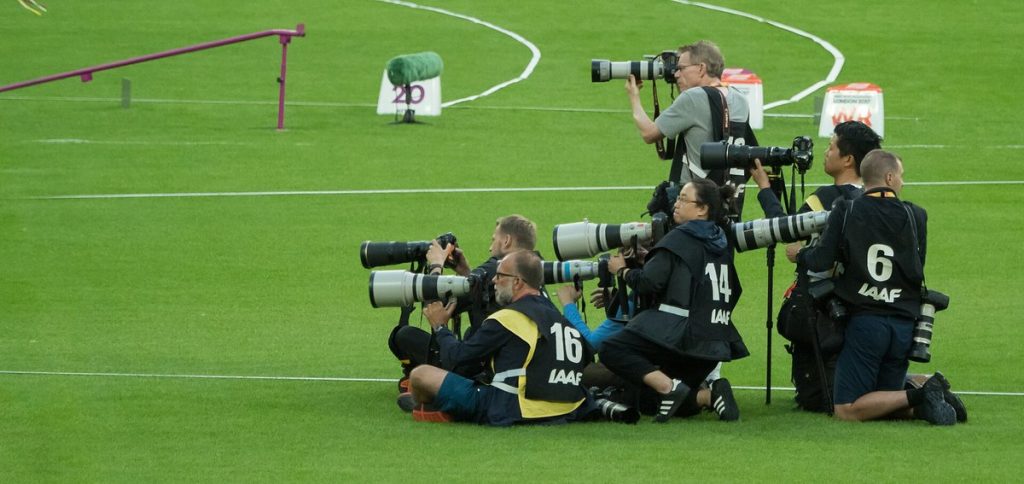 Fotoreporterzy z teleobiektywami na stadionie lekkoatletycznym