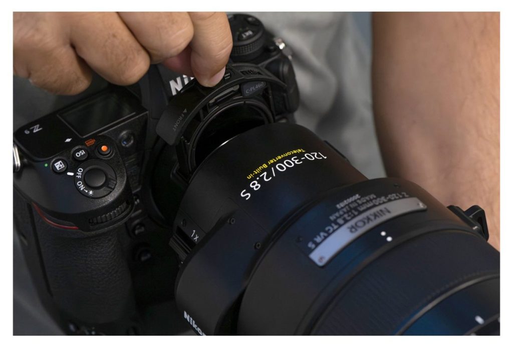 Nikon Z9 z obiektywem NIKKOR Z 120-300 mm f/2.8 TC VR S w dłoniach fotografa