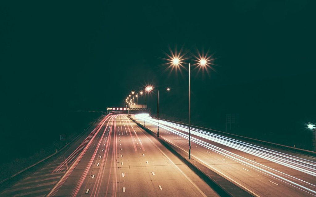 Smugi świateł samochodów na autostradzie nocą, długie naświetlanie