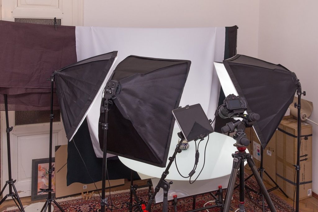 Profesjonalne studio do zdjęć produktowych z czterema softboksami, stołem bezcieniowym i aparatem na statywie