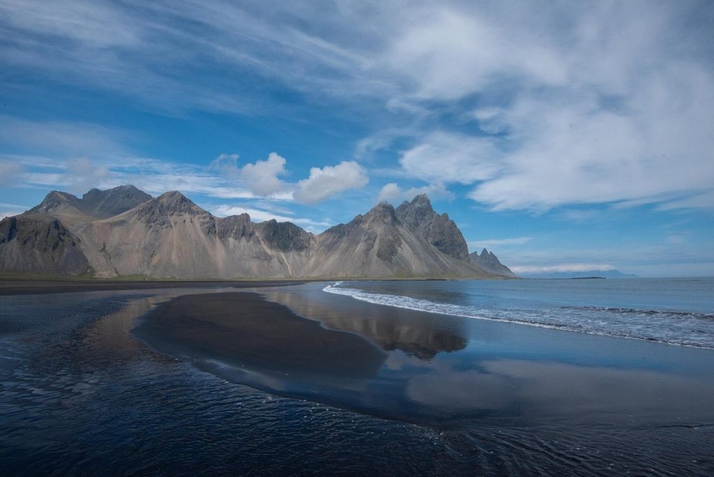 Góra Vestrahorn i czarna plaża Stokksnes na Islandii, odbicie gór w mokrym piasku