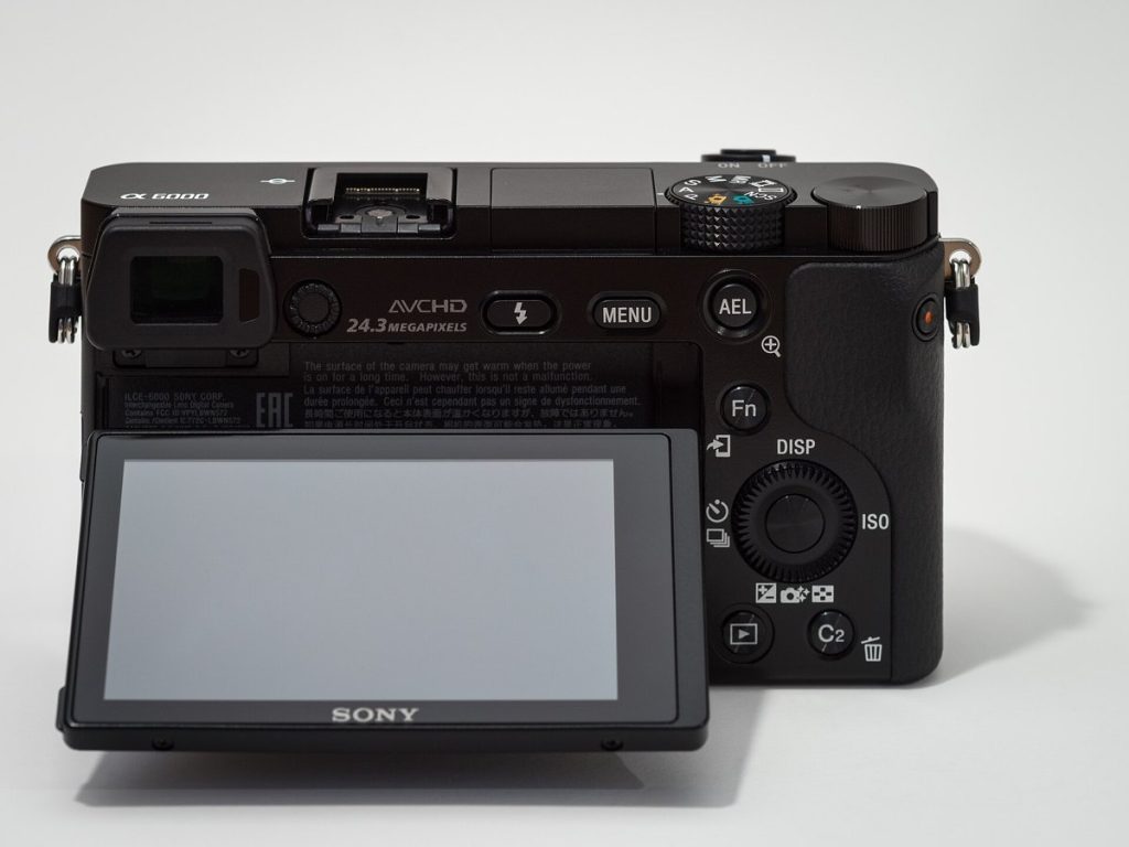 Tył aparatu bezlusterkowego Sony z odchylonym ekranem i przyciskiem MENU